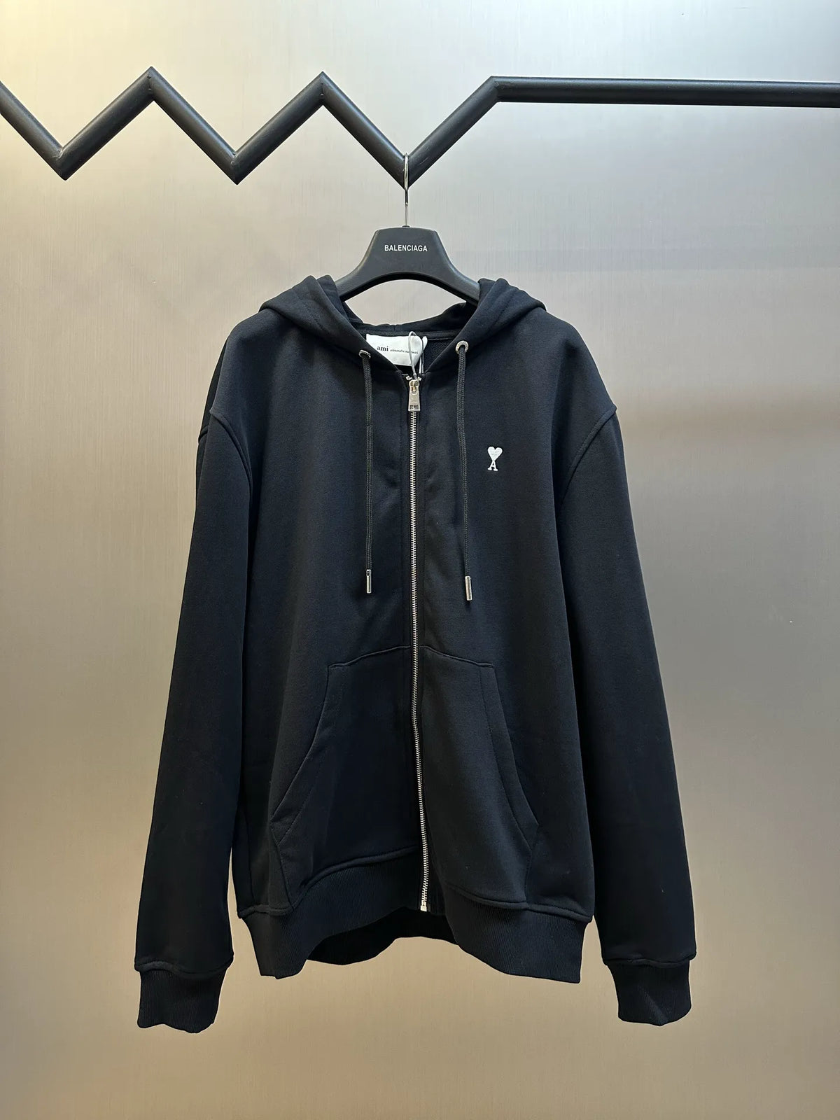 Black zip-up hoodie with hood, drawstrings, and front kangaroo pocket