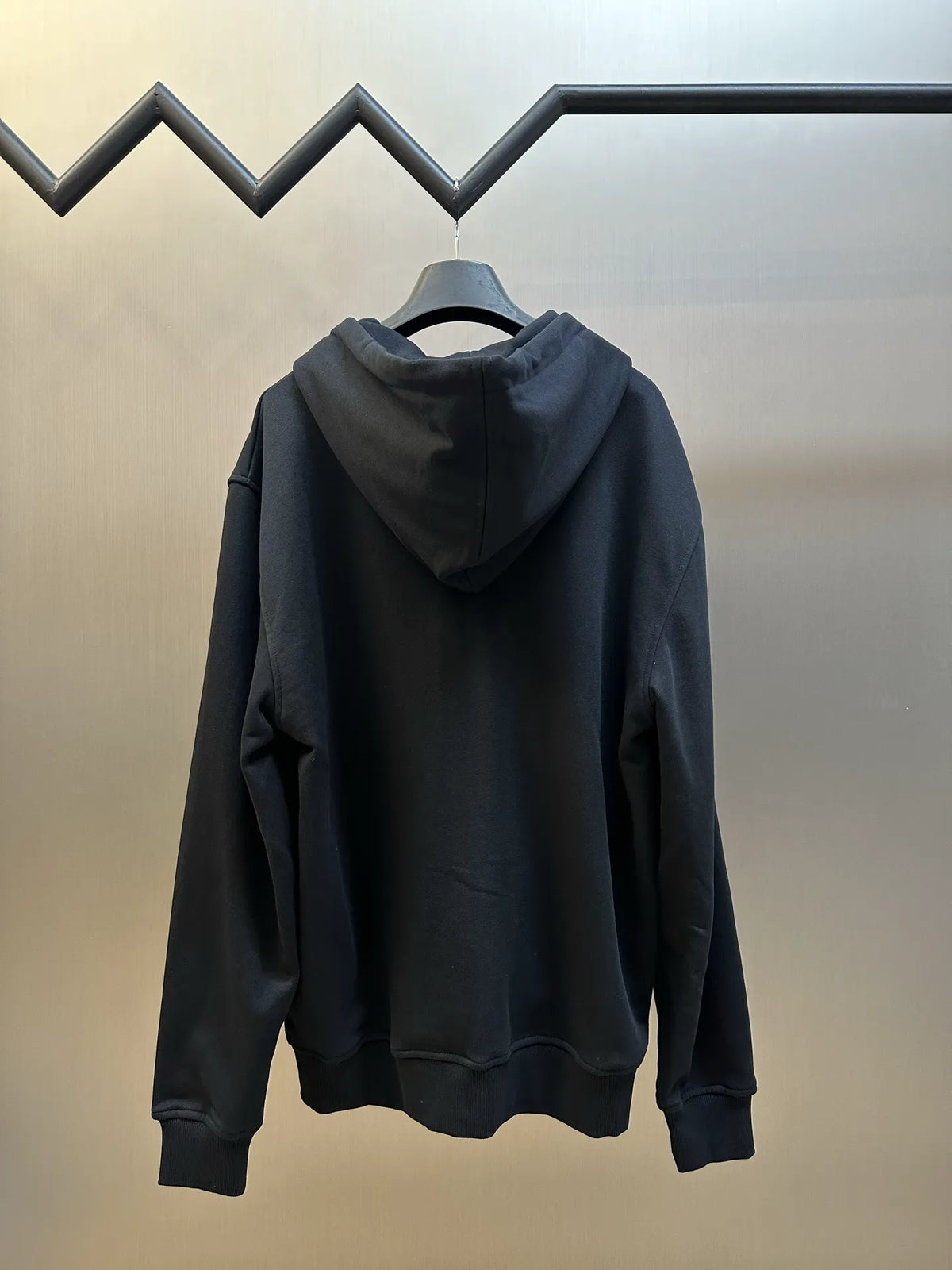 Black zip-up hoodie back view with hood and full-length zipper