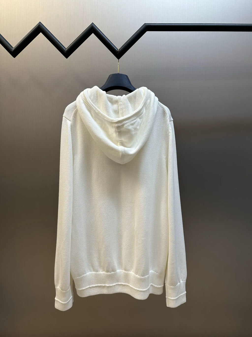 Cream hooded sweatshirt on hanger, back view with ribbed hem and cuffs