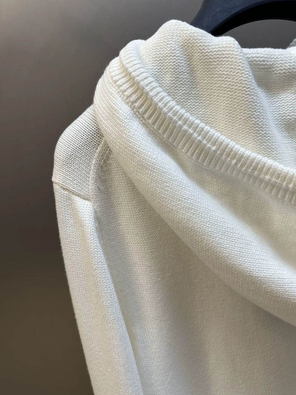 Cream hoodie sleeve detail with ribbed knit cuff and textured fabric