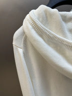 Cream hoodie sleeve detail with ribbed knit cuff and textured fabric