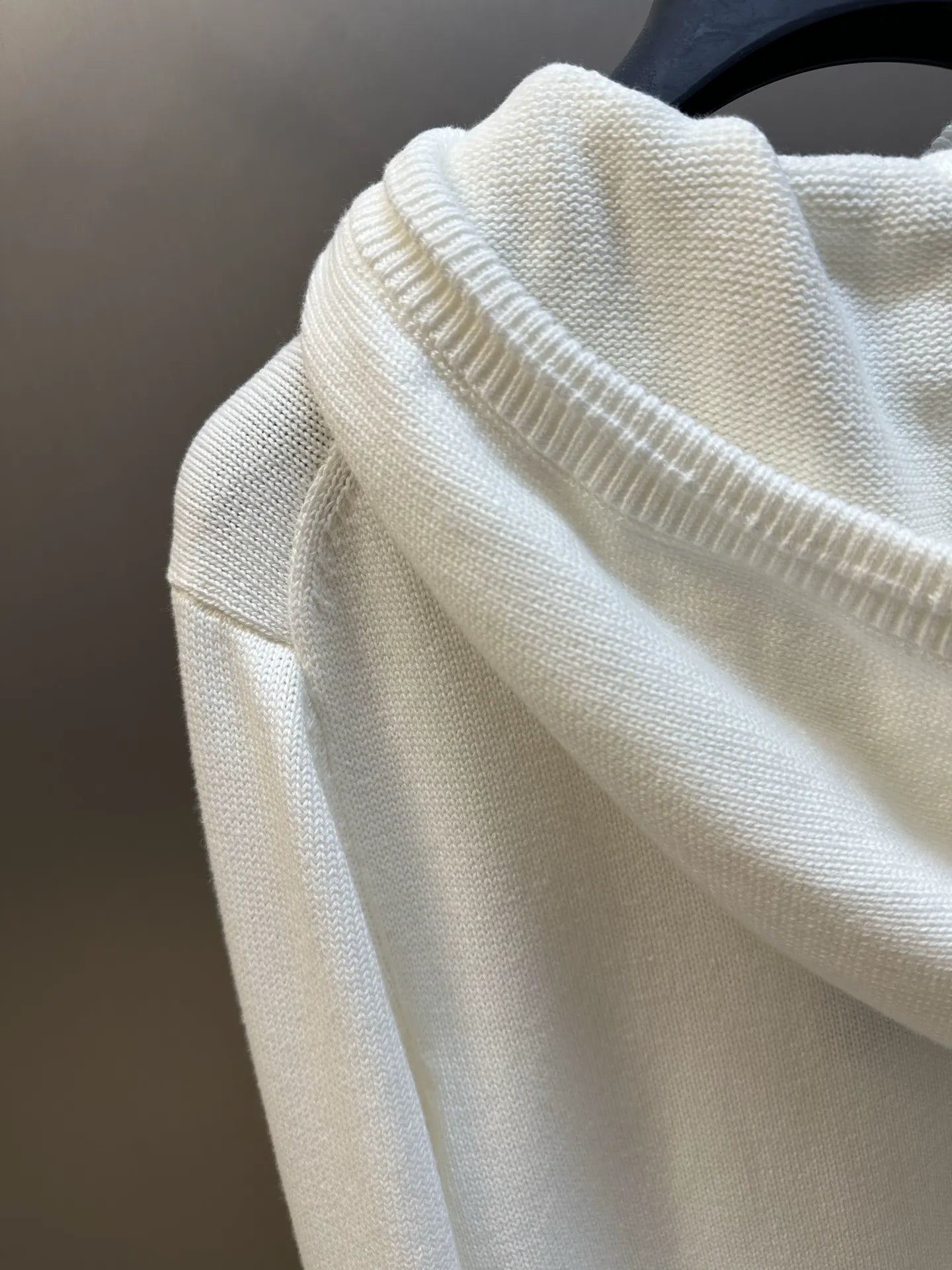 Cream hoodie sleeve detail with ribbed knit cuff and textured fabric