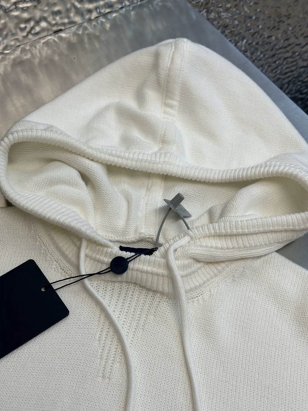 Cream knit hoodie with drawstring hood and interior black tag