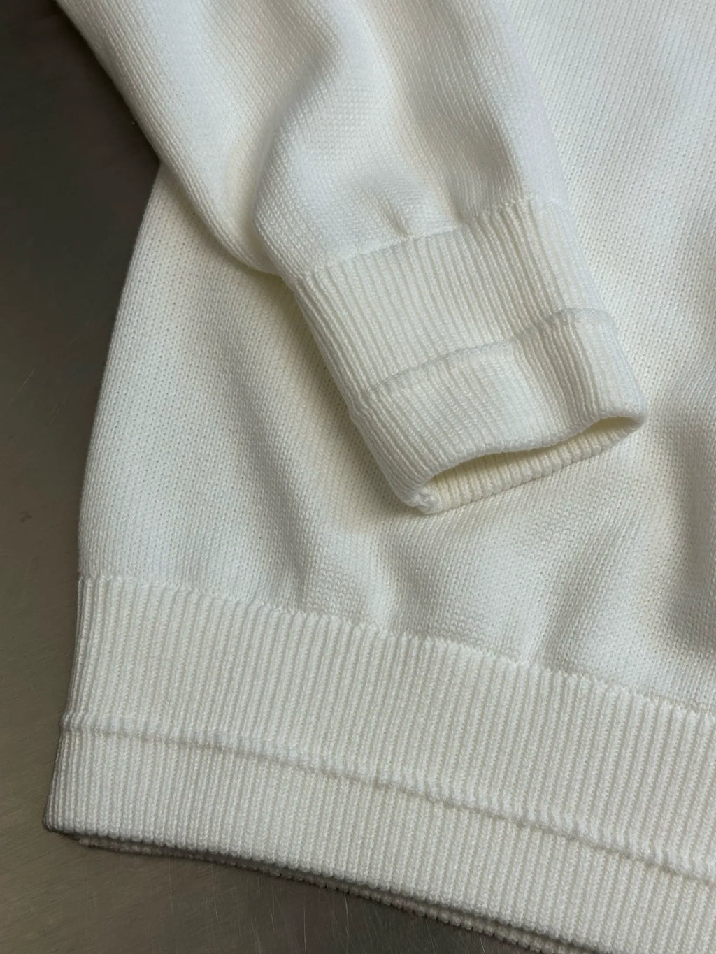 Cream hoodie with ribbed hem and sleeve cuffs visible in close-up