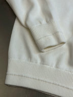 Cream hoodie with ribbed hem and sleeve cuffs visible in close-up
