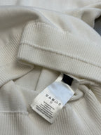 Cream hoodie neckline close-up with interior care label tag