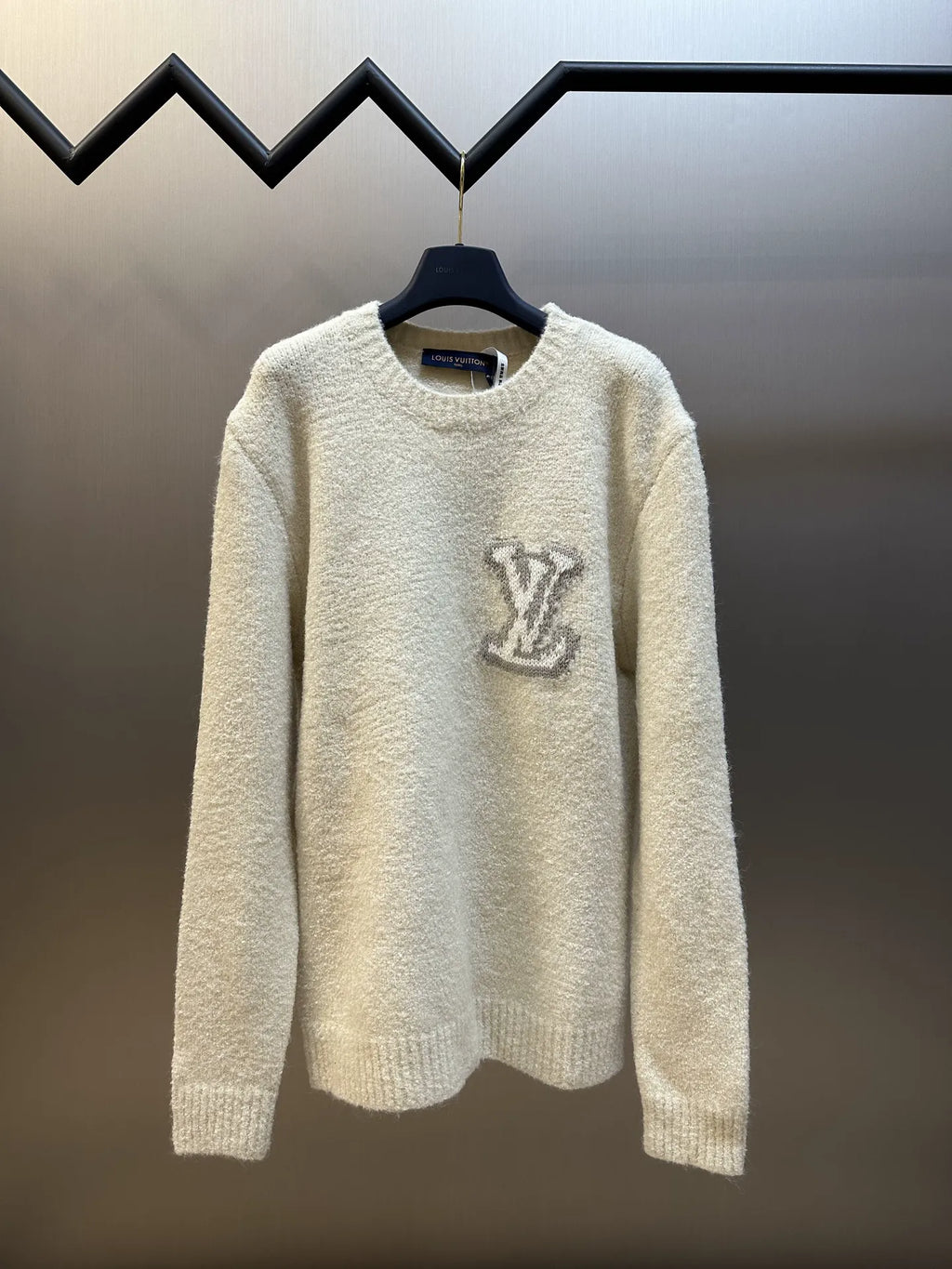 Off-white long-sleeve crewneck knit sweater with LV-style monogram on the chest