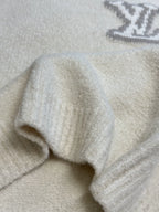 Off-white knit sweater with ribbed cuffs and visible sleeve seam detail