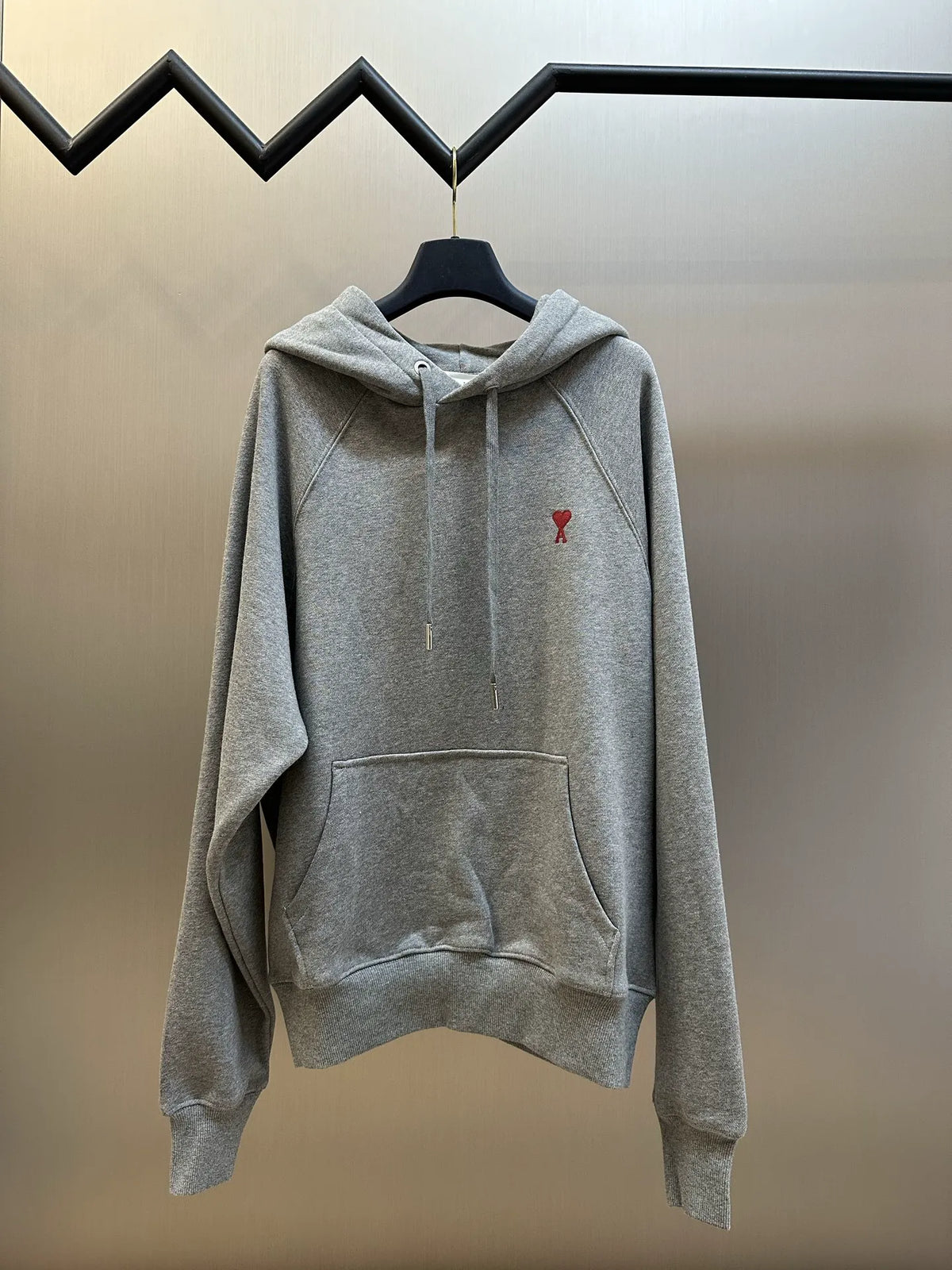 Heather gray pullover hoodie with kangaroo pocket, drawstring hood, red logo on chest