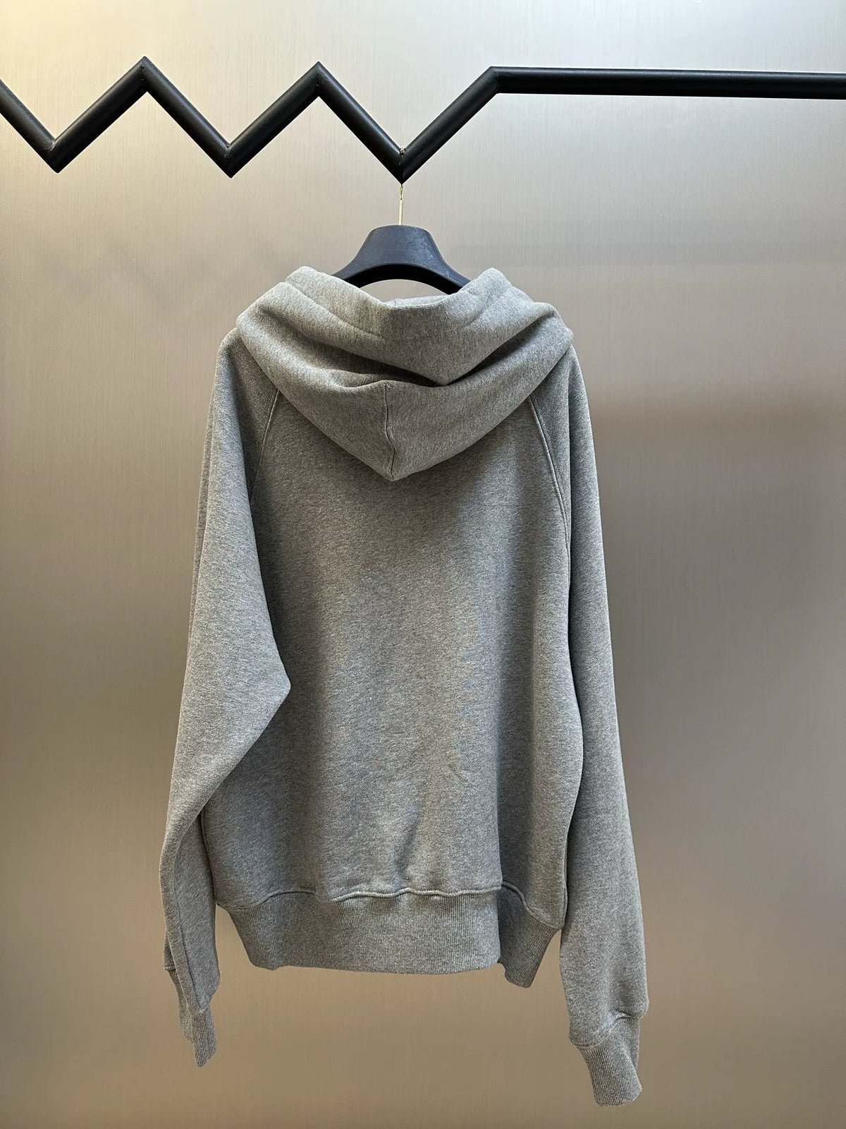 Heather gray pullover hoodie viewed from back with ribbed hem and pocket opening