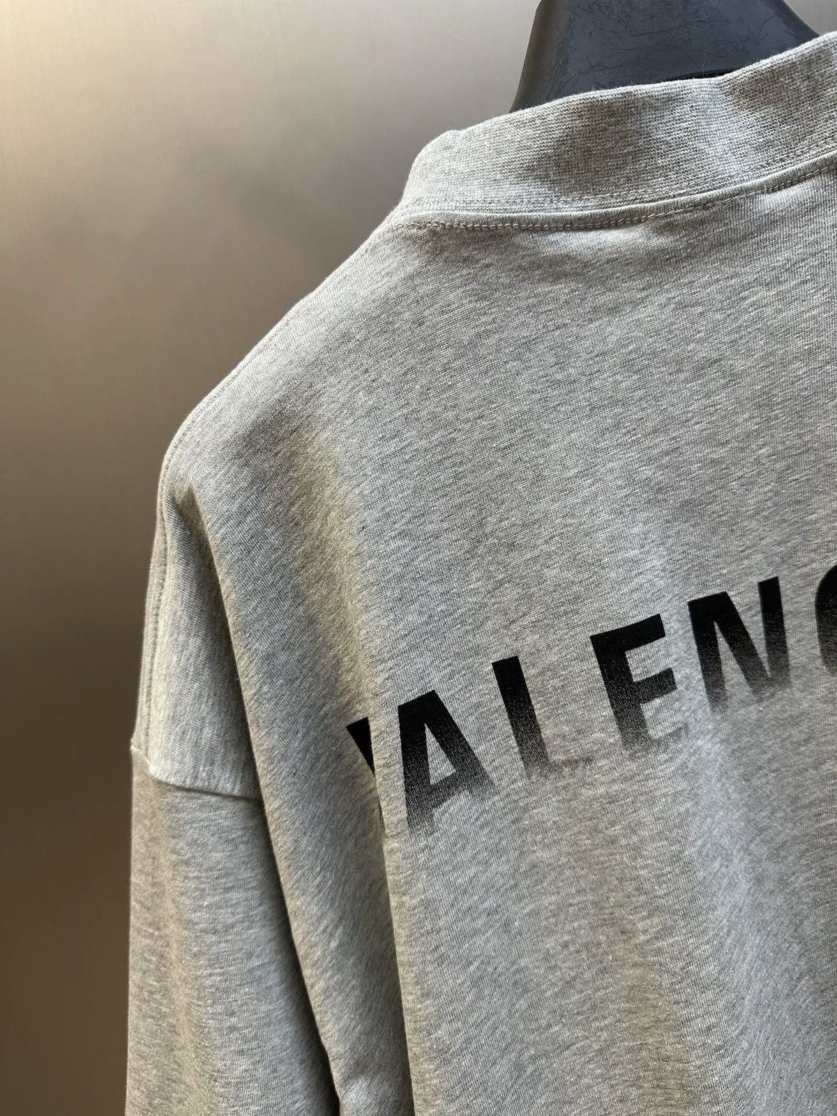 Light gray T-shirt close-up of large 'BALENCIAGA' lettering on upper back