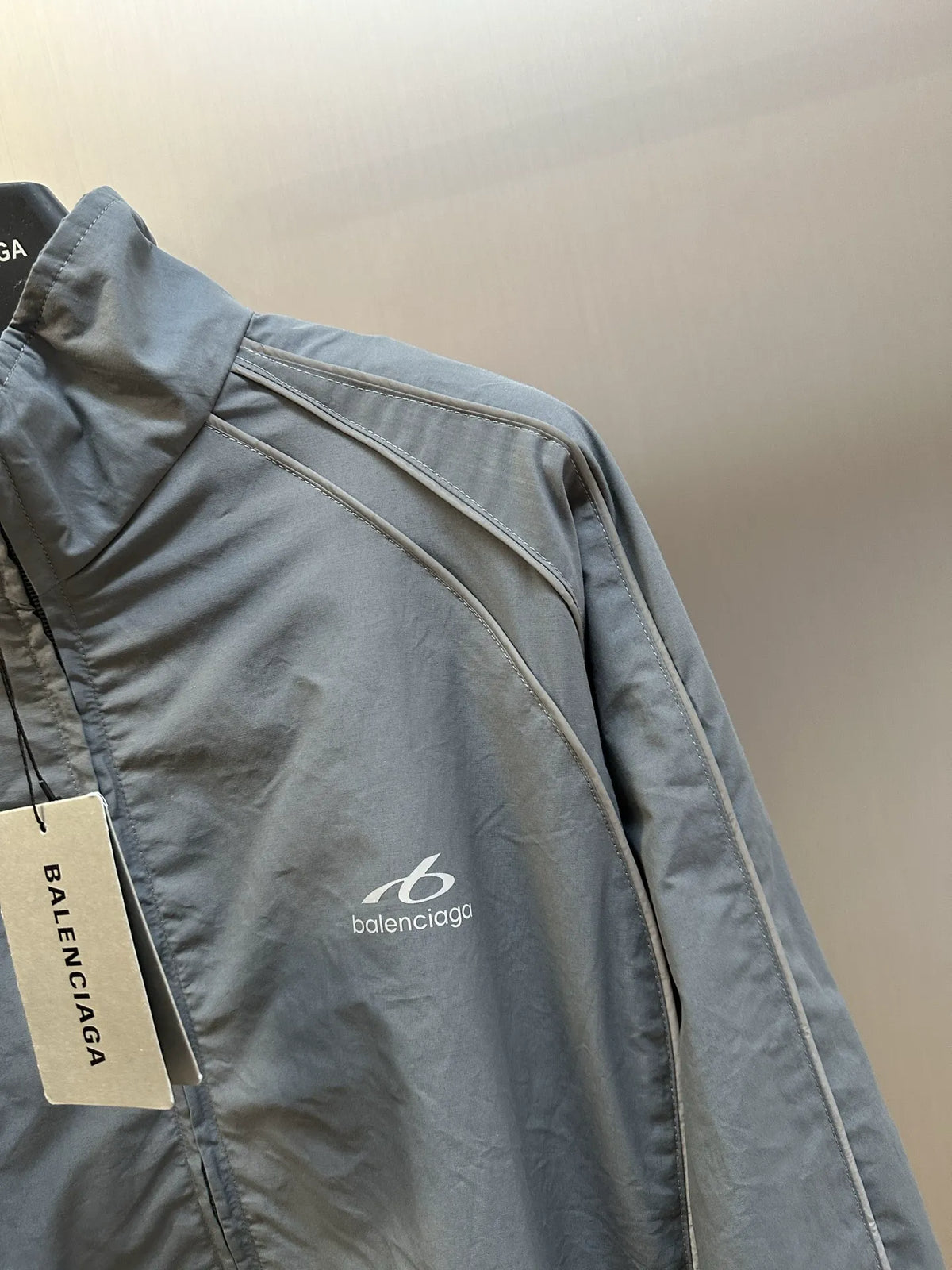 Light blue-gray jacket with contrast piping and small chest logo