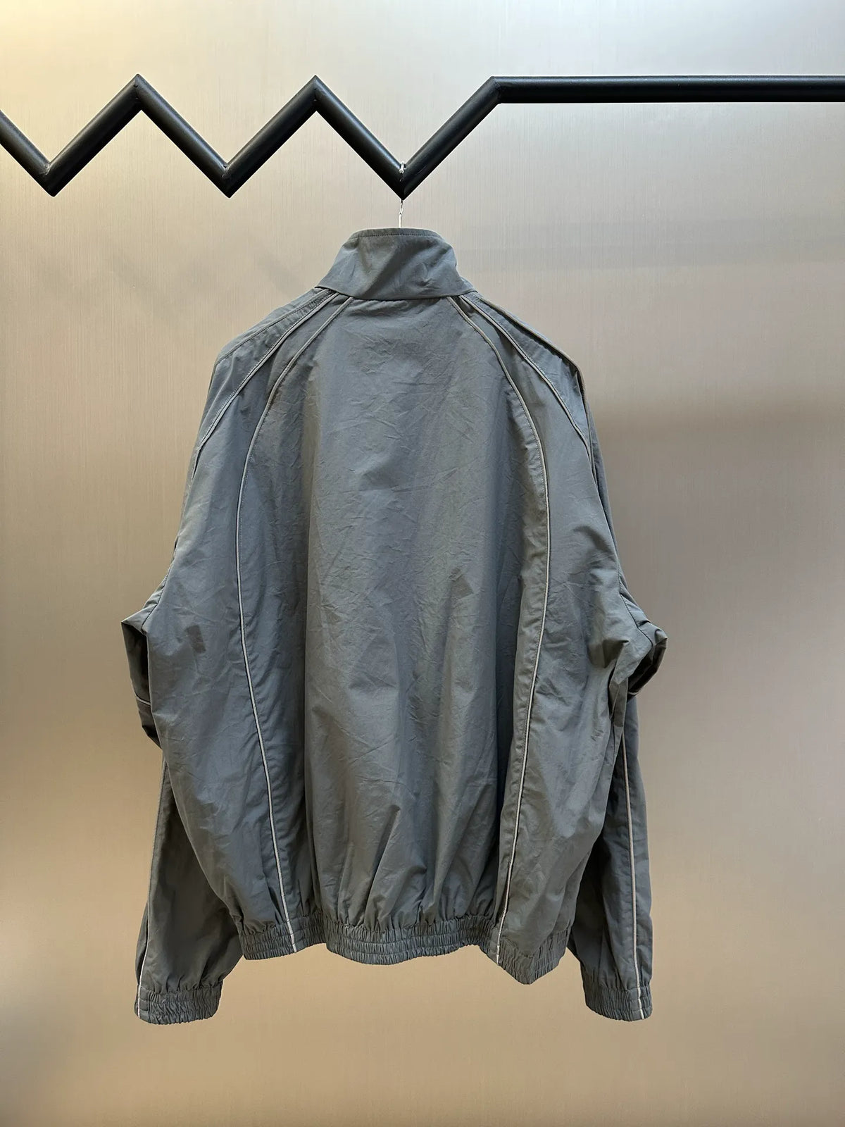 Light blue-gray zip-up jacket back view with stand collar and loose sleeves