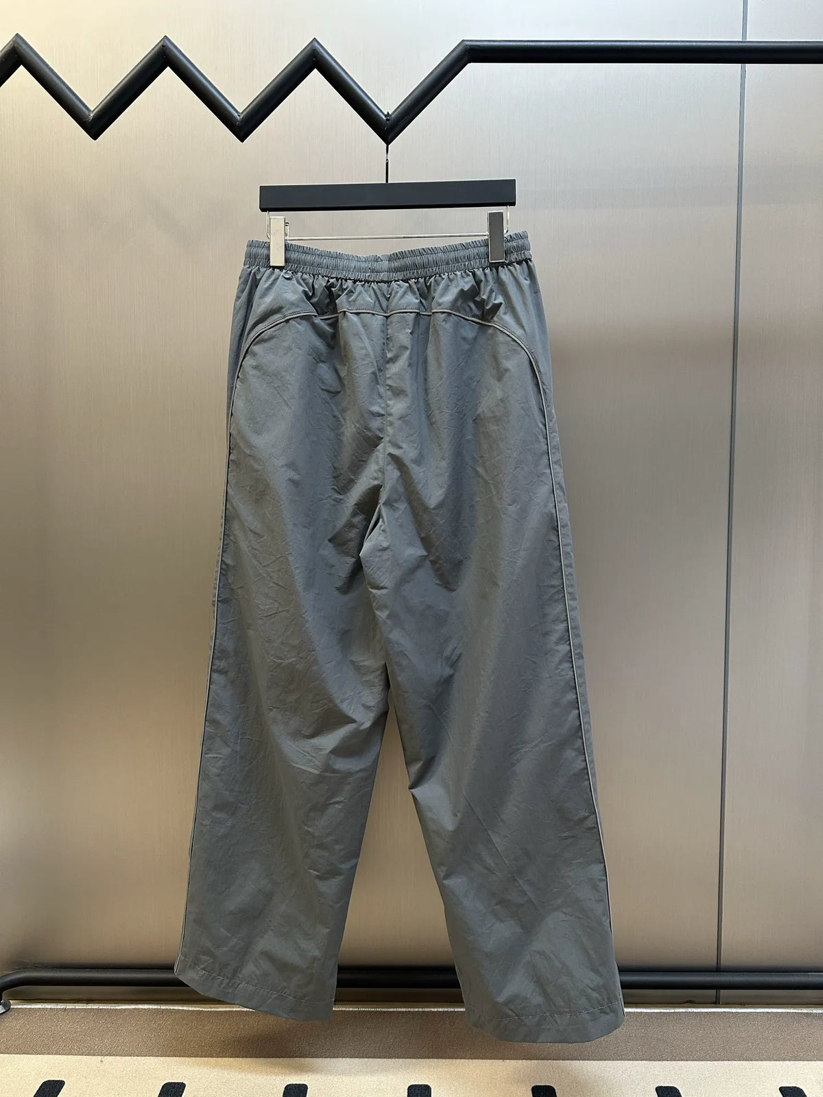 Light gray Balenciaga pants back view with elastic waistband and wide-leg silhouette