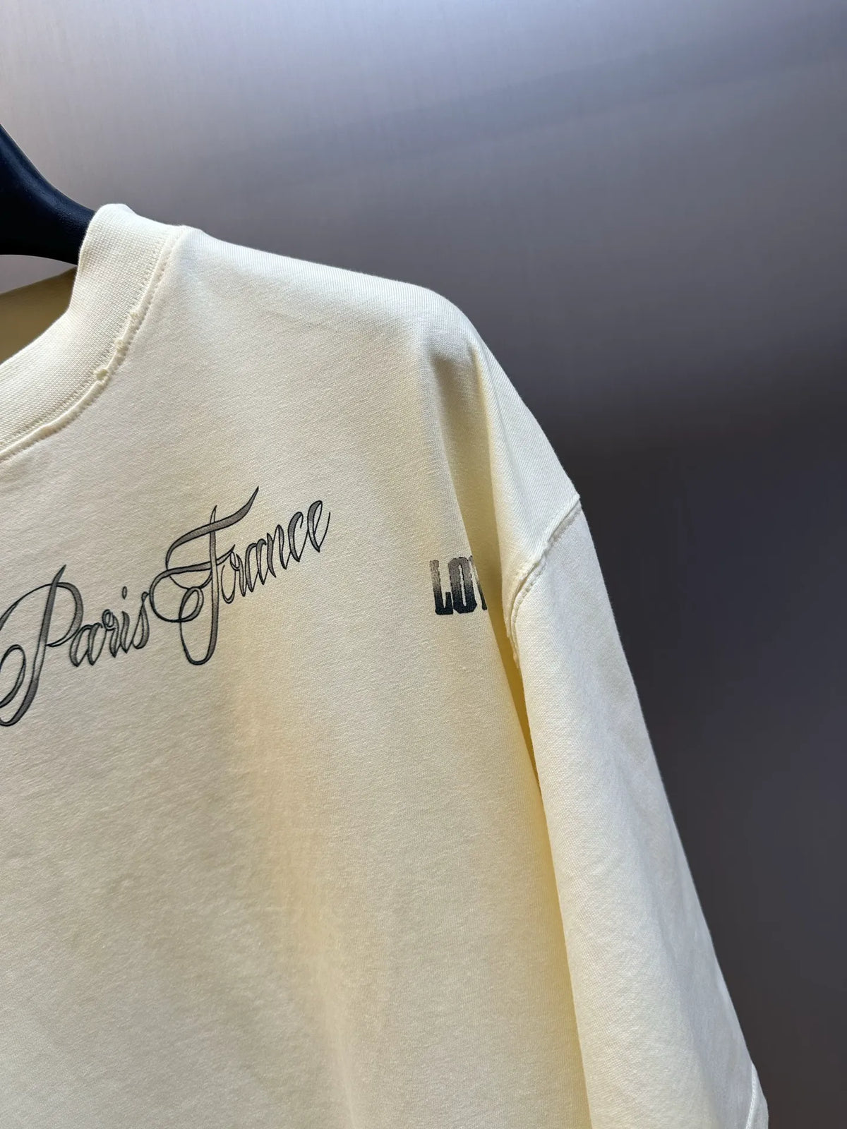 Cream short-sleeve T-shirt with side script graphic and small text detail