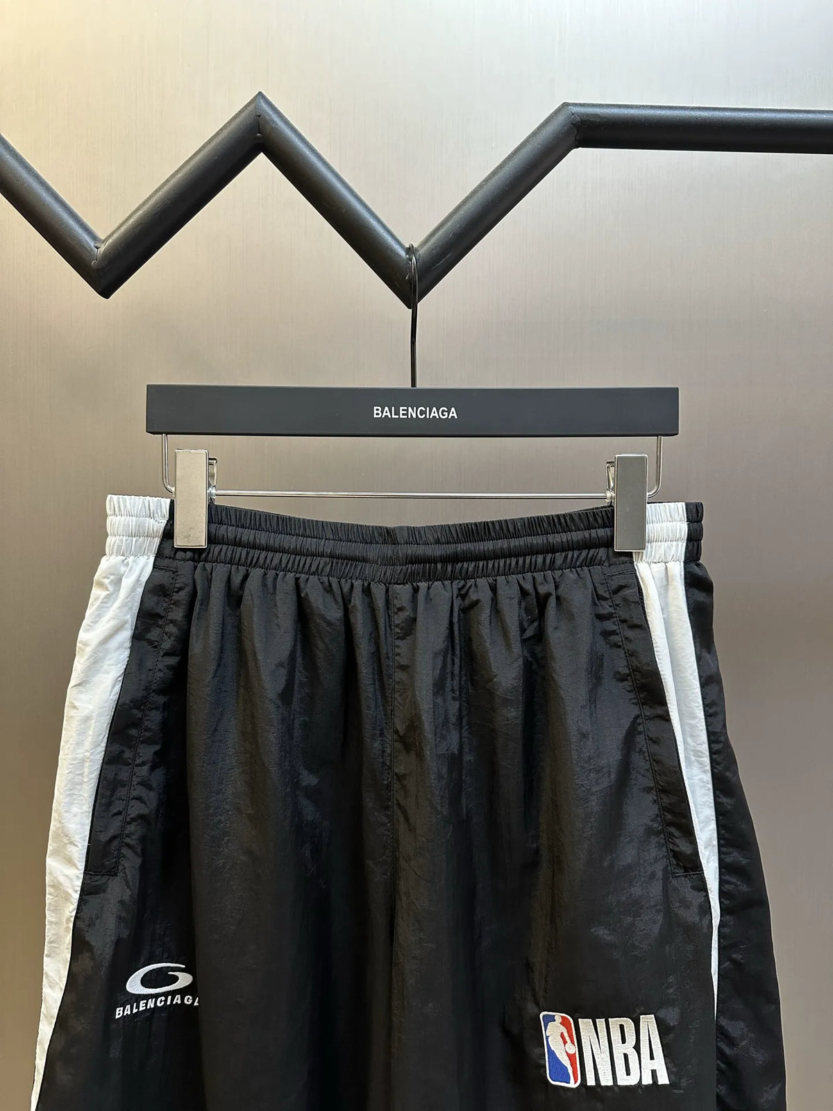 Balenciaga black shorts with elastic waistband and white side stripe, NBA logo patch