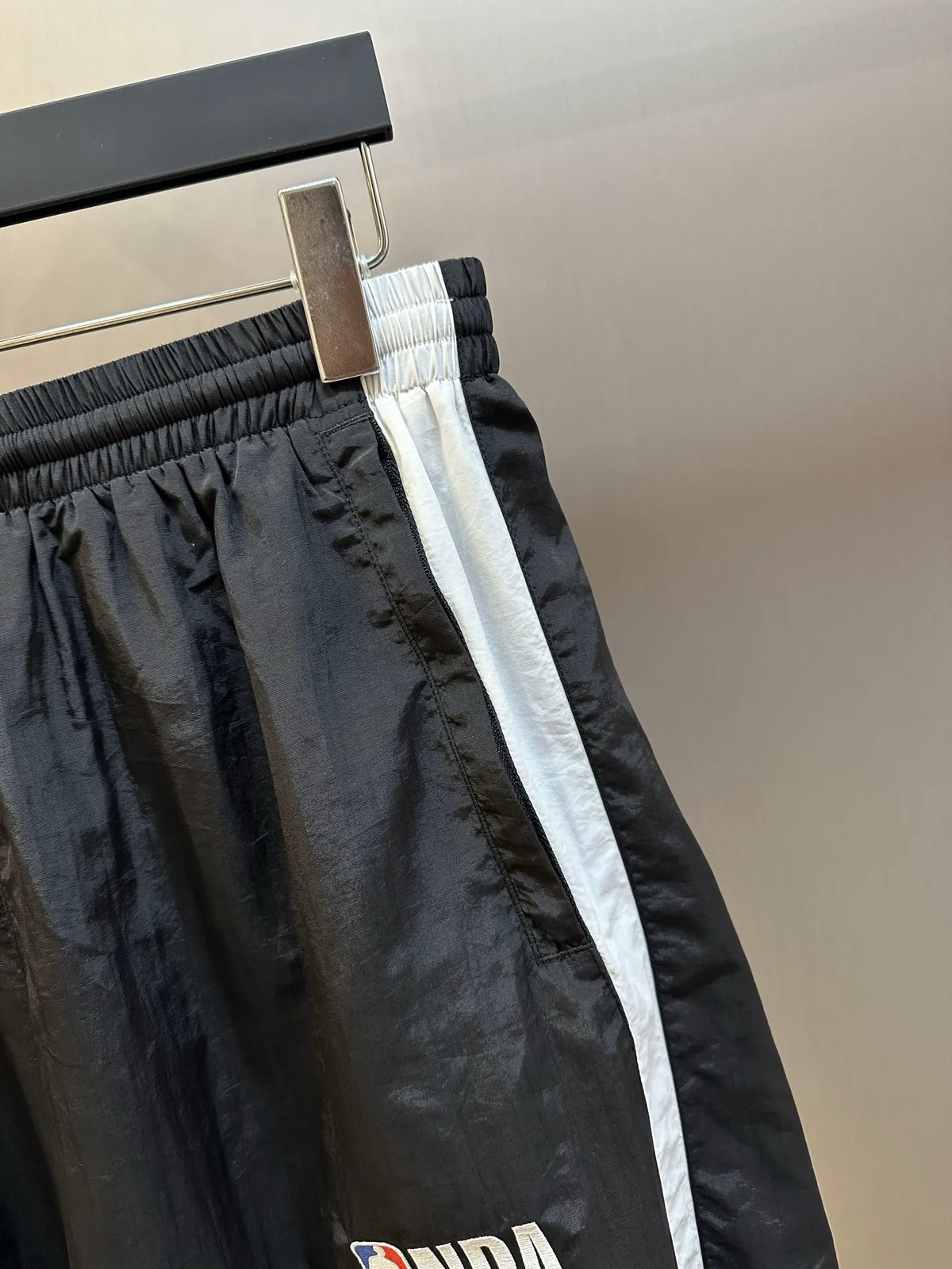 Balenciaga shorts close-up: elastic waistband, silver buckle, and white side stripe