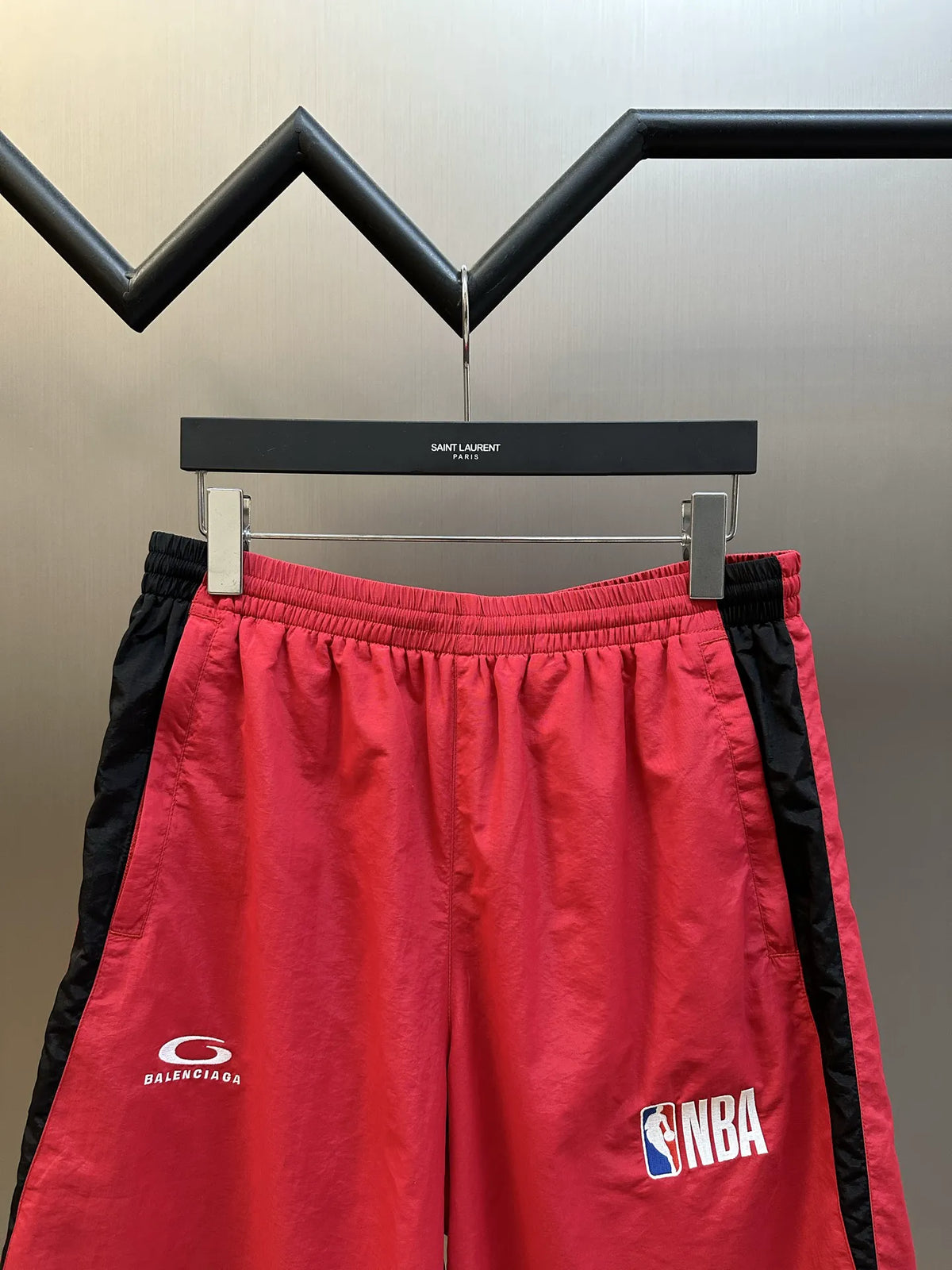 Balenciaga red basketball shorts with elastic waistband and black trim, front NBA patch