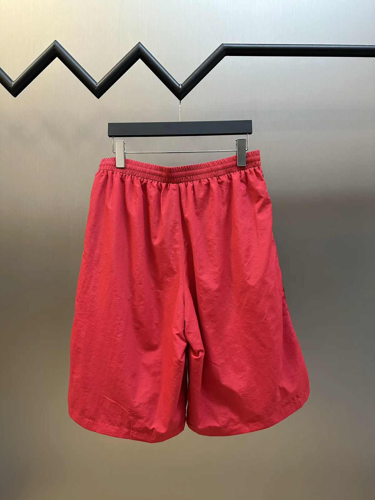 Balenciaga red basketball shorts with elastic waistband and black accent stripes
