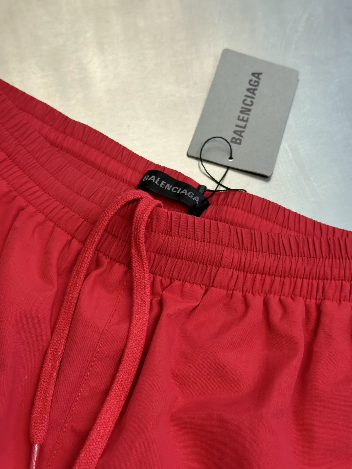Balenciaga red basketball shorts front view with elastic waistband and BALENCIAGA label