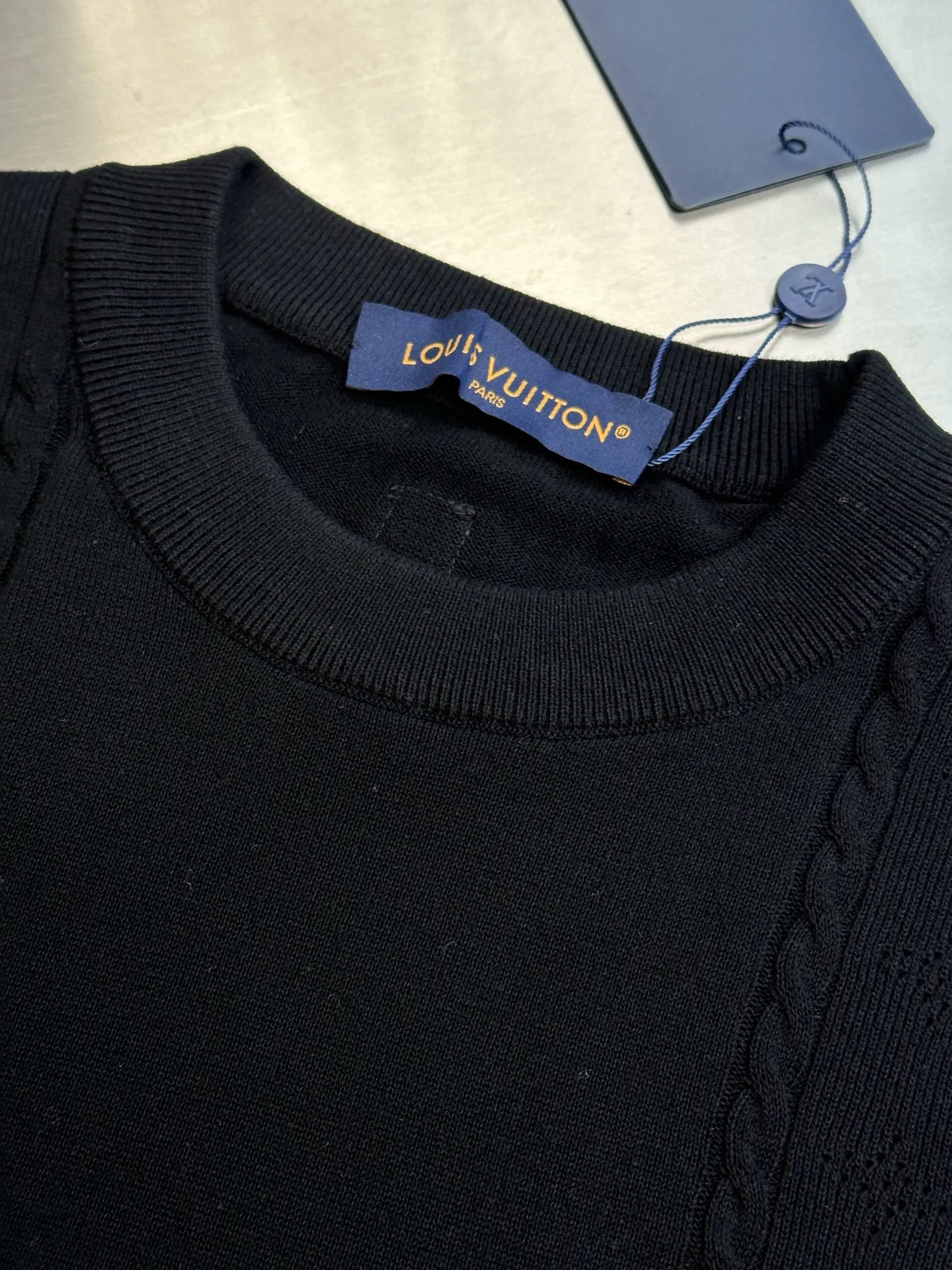 Black crew-neck sweater with ribbed collar and Louis Vuitton neck label