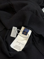 Black sweater with attached size and care tags