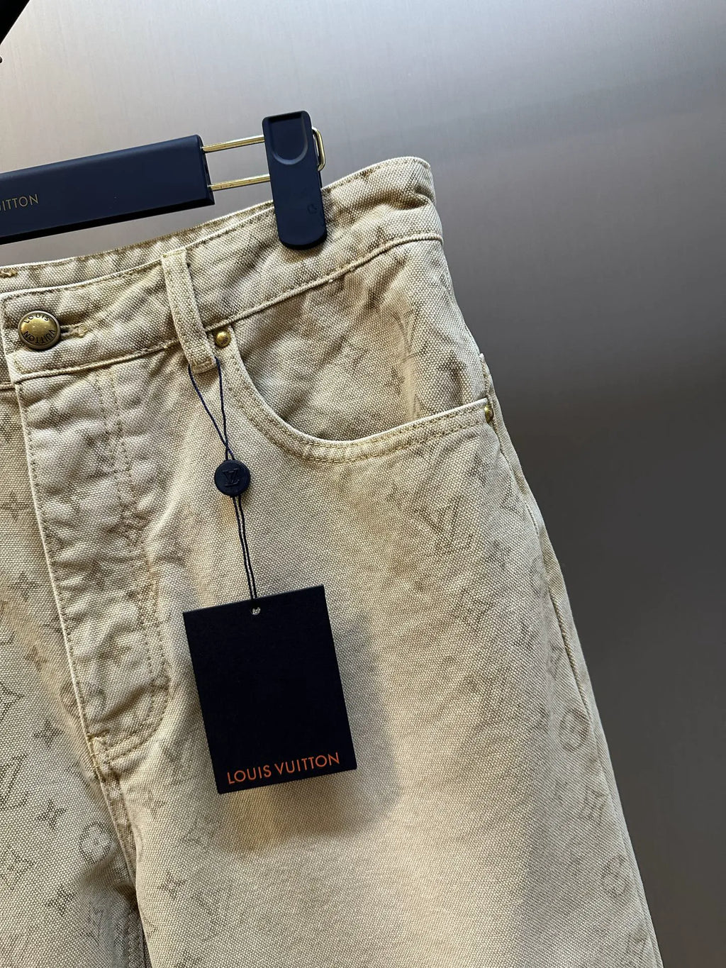 Light beige LV monogram denim pants, side view with front pocket and logo tag