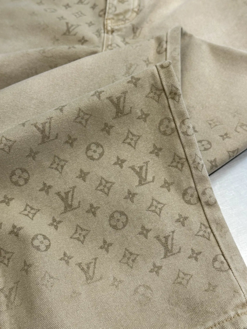 Light beige LV monogram pants, leg and side seam detail with visible button