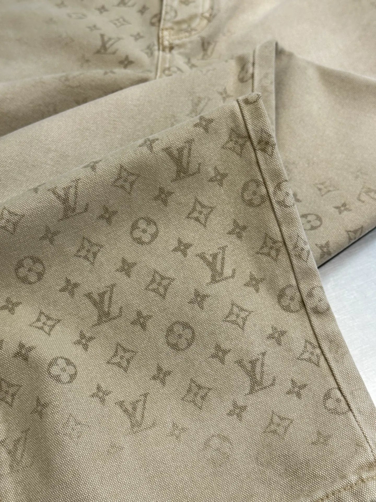 Light beige LV monogram pants, leg and side seam detail with visible button