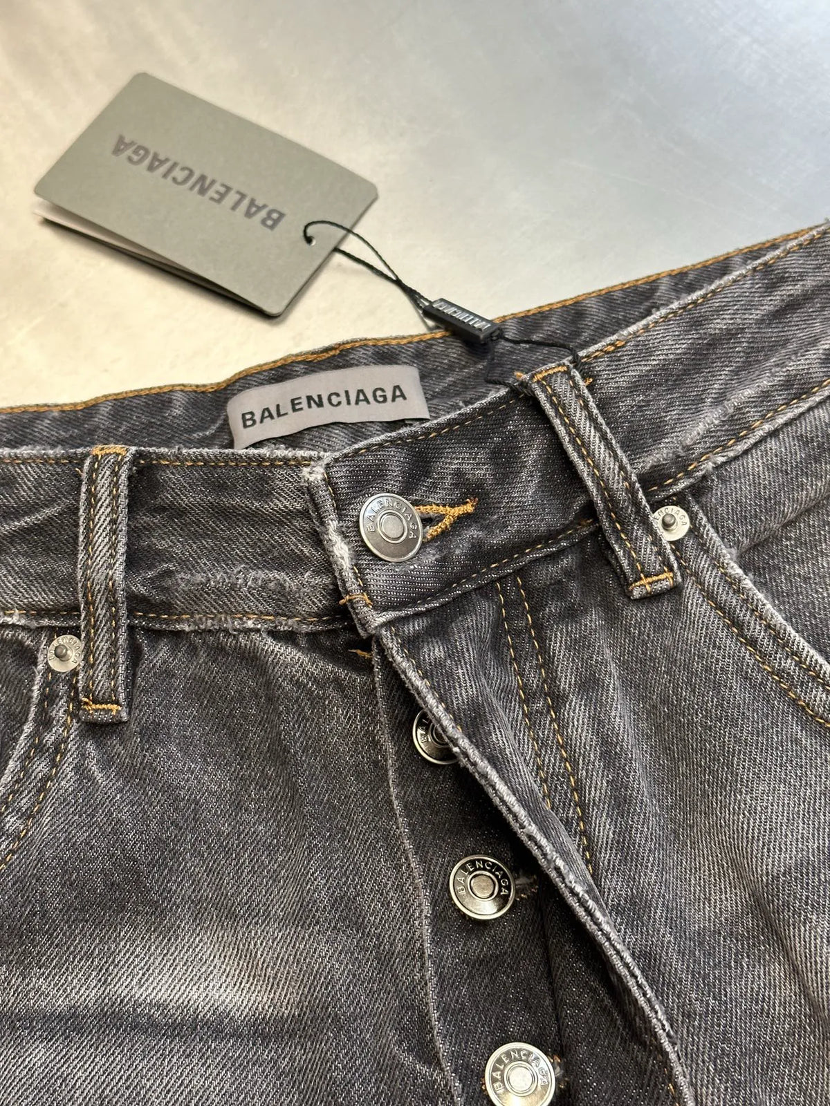 Balenciaga dark blue denim waistband with logo patch, button placket, and product tag