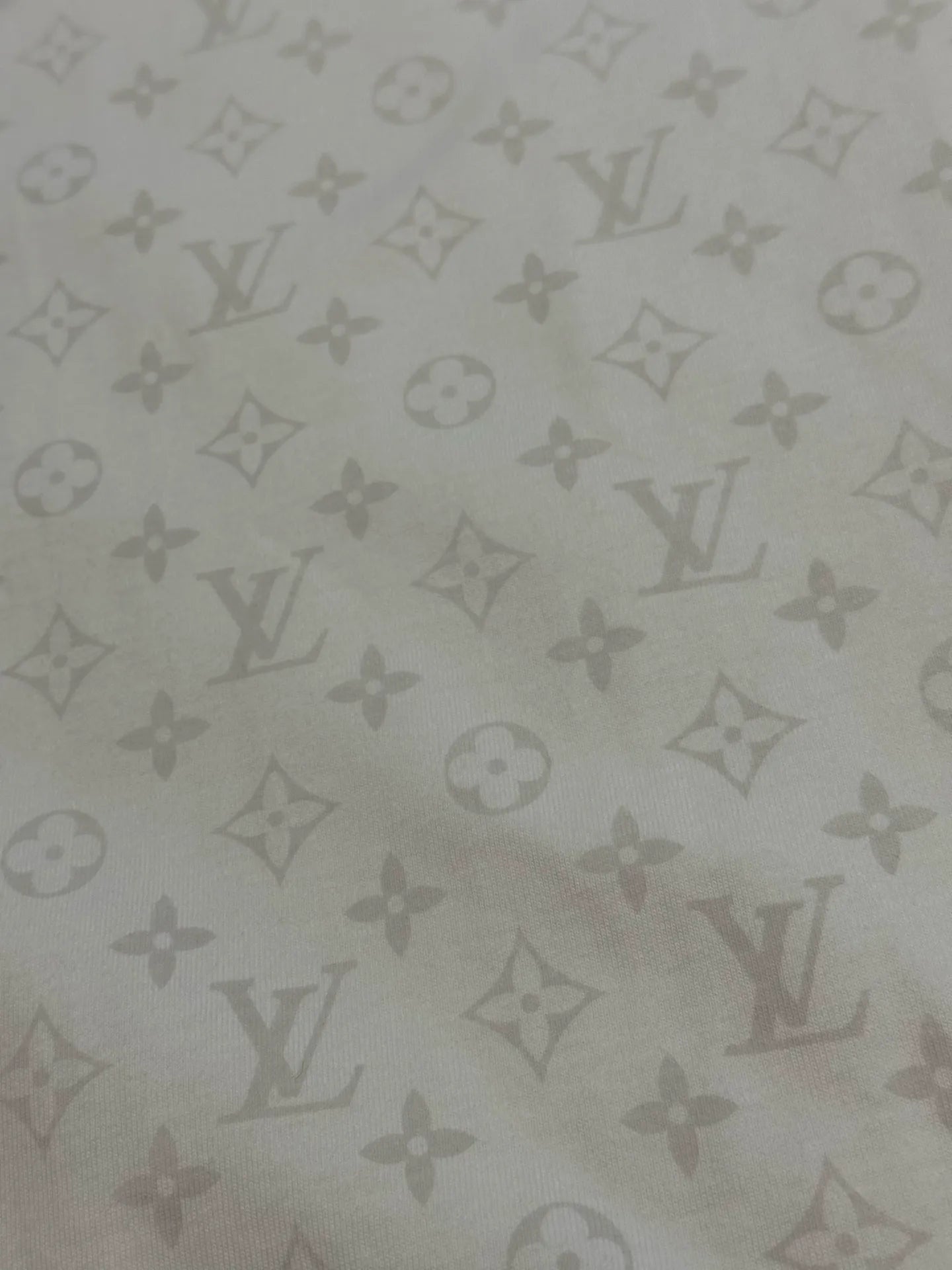 Light fabric with repeating monogram pattern, close-up