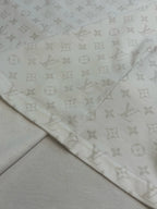 Folded T-shirt fabric with repeating monogram print along hem