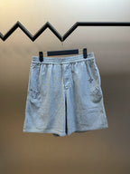 Light blue linen-blend shorts with elastic waistband and embroidered symbols