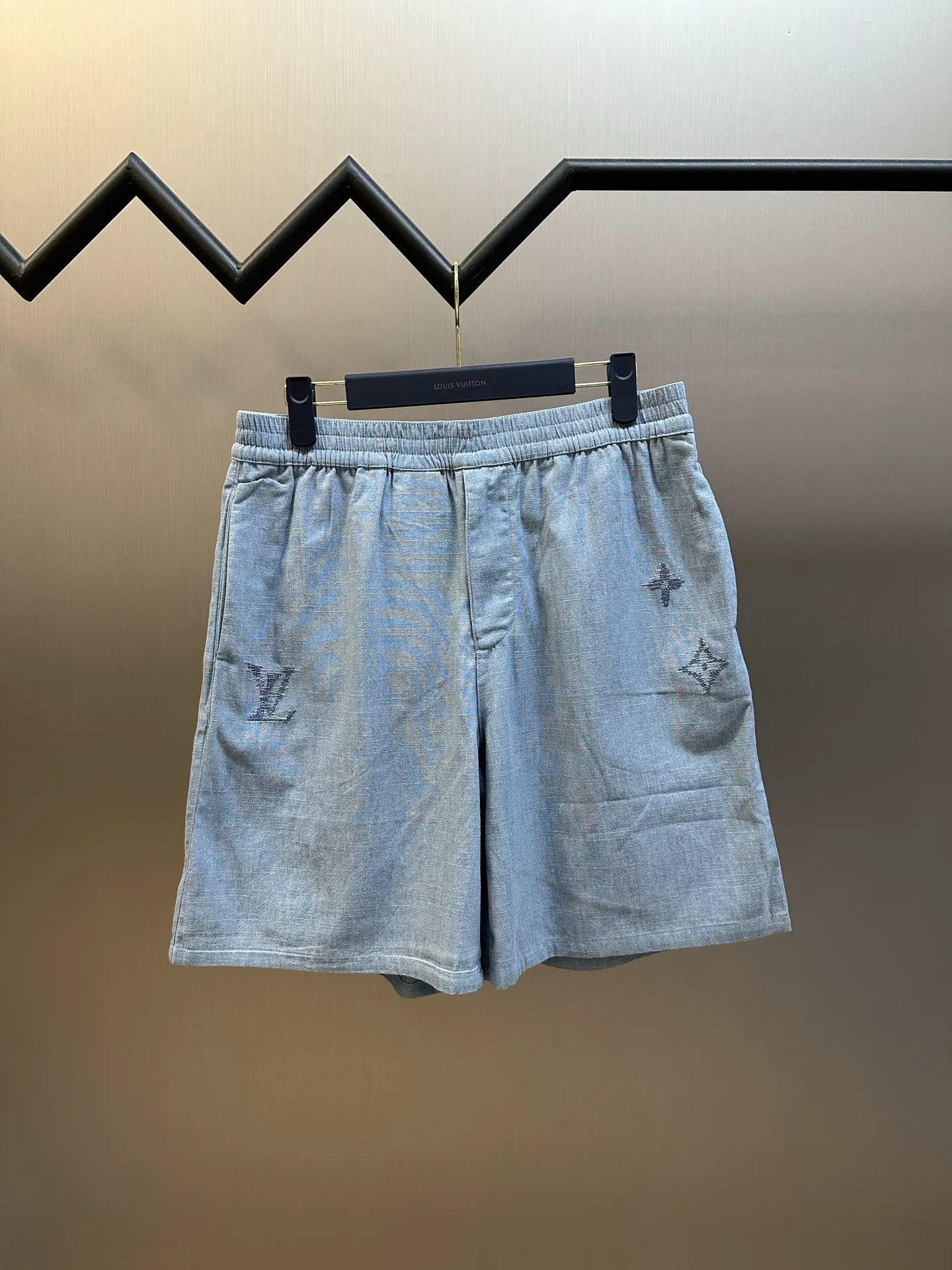 Light blue linen-blend shorts with elastic waistband and embroidered symbols
