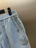 Light blue shorts detail: elastic waistband and embroidered star-like motif