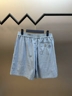 Light blue shorts with elastic waist, front pocket, and embroidered emblem