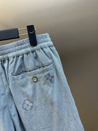 Light blue shorts front pocket detail with embroidered star-like markings