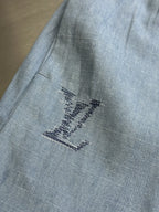 Light blue fabric shorts with embroidered star-like design on leg