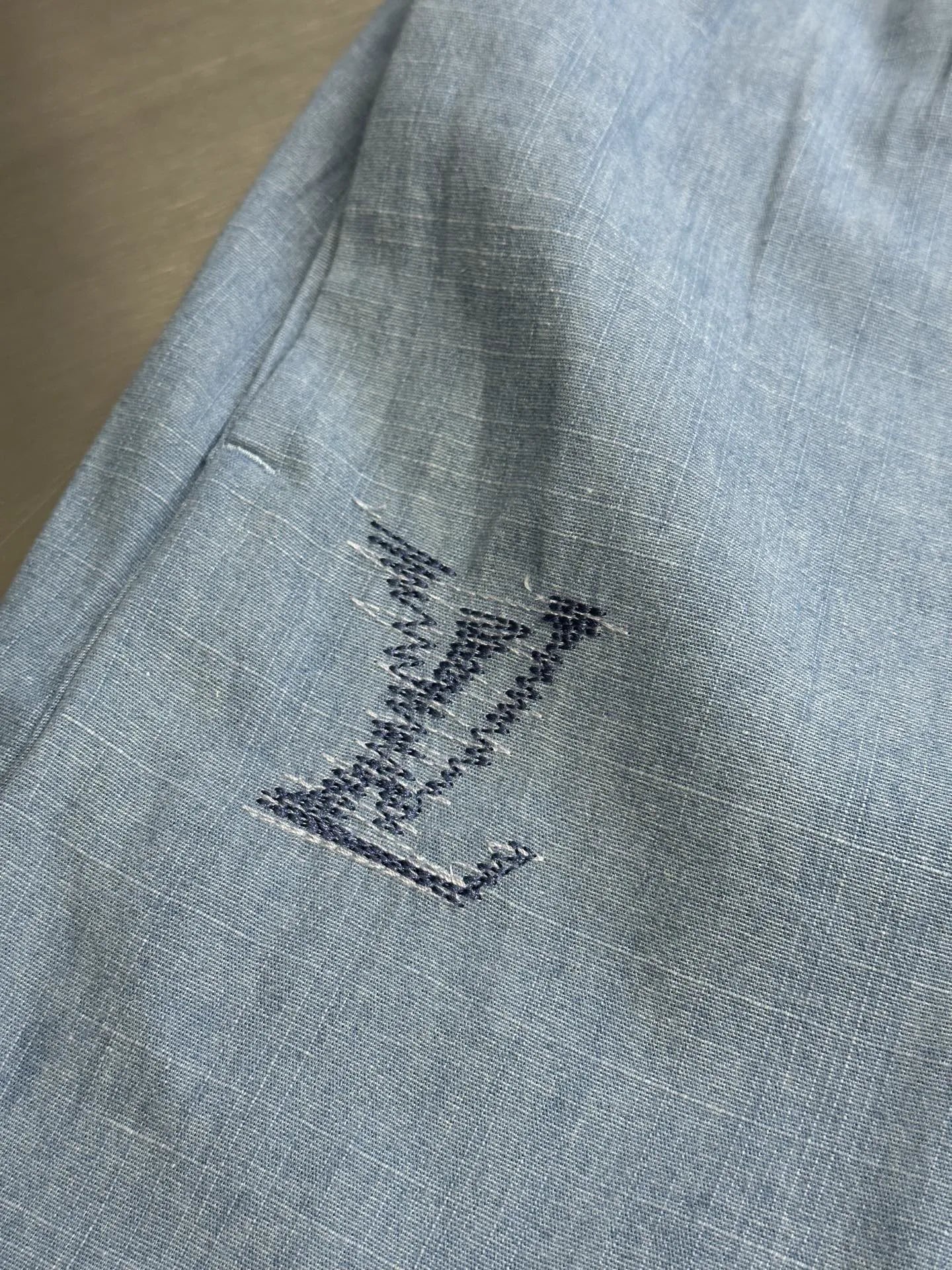 Light blue fabric shorts with embroidered star-like design on leg