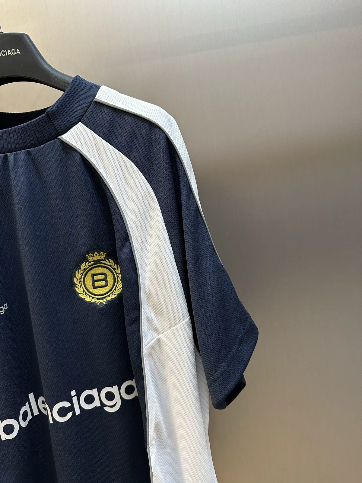 Balenciaga jersey shirt sleeve with white stripe and gold crest patch on navy