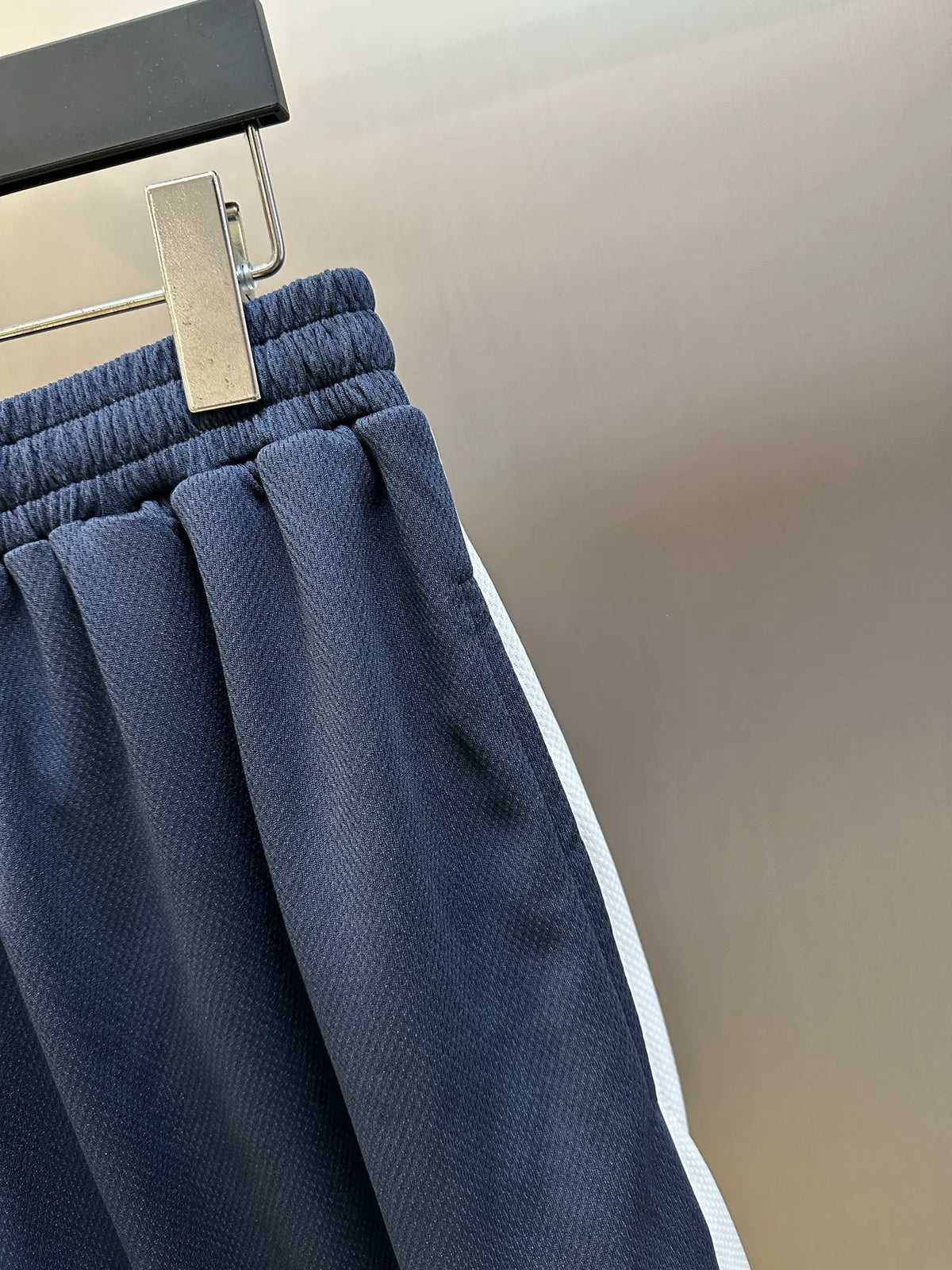 Navy pleated shorts with elastic waistband and structured side seams