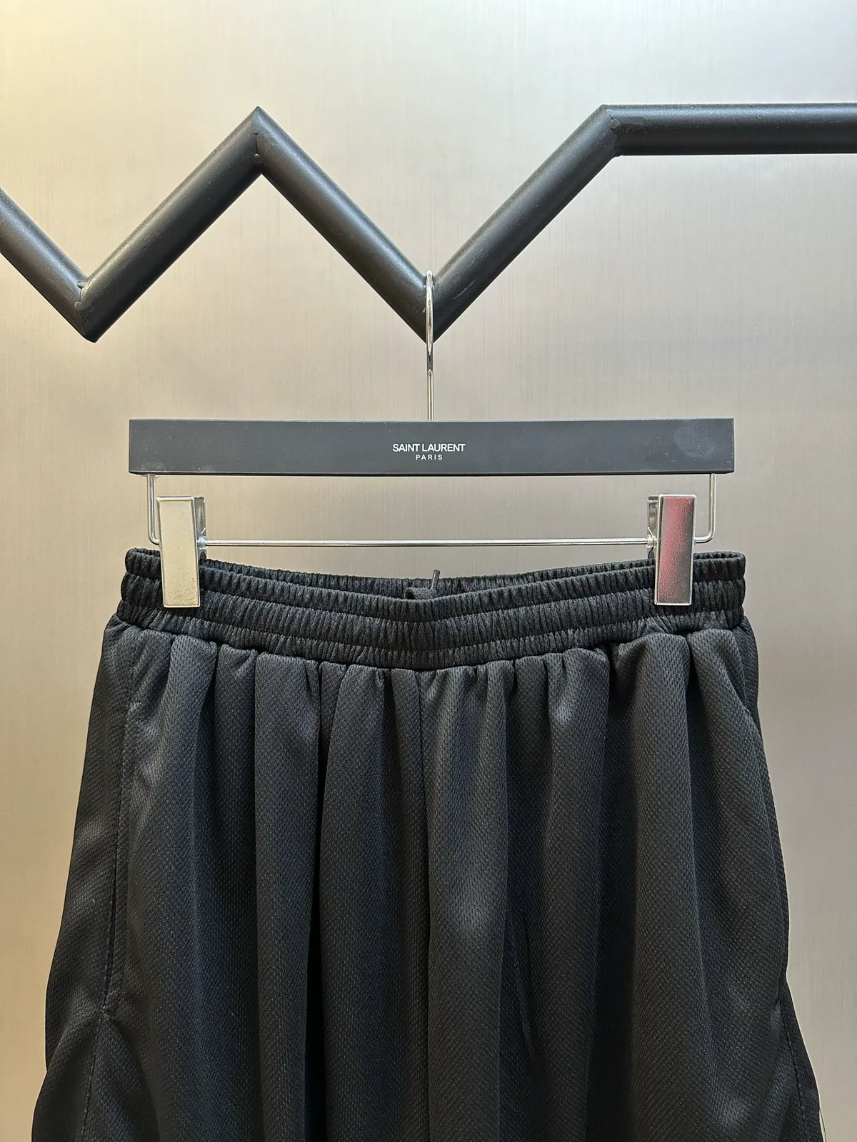 Black elastic-waist shorts with textured fabric and waistband snap detail