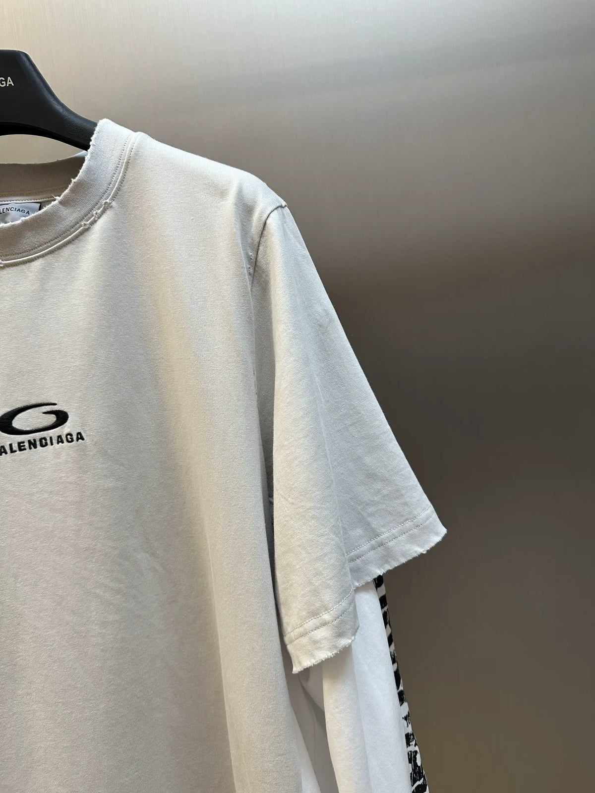 White Balenciaga T-shirt sleeve with black logo print, loose fit.
