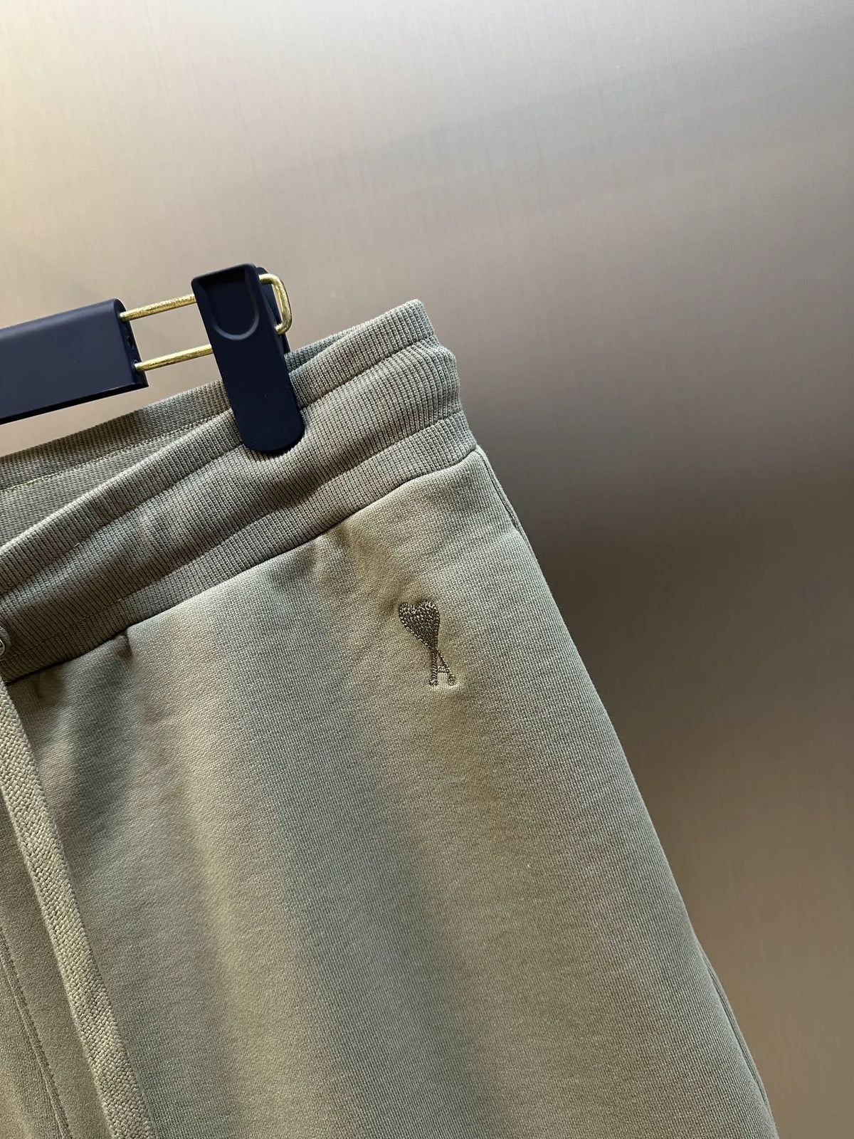 Light taupe shorts detail with drawstring eyelets and small left-leg emblem