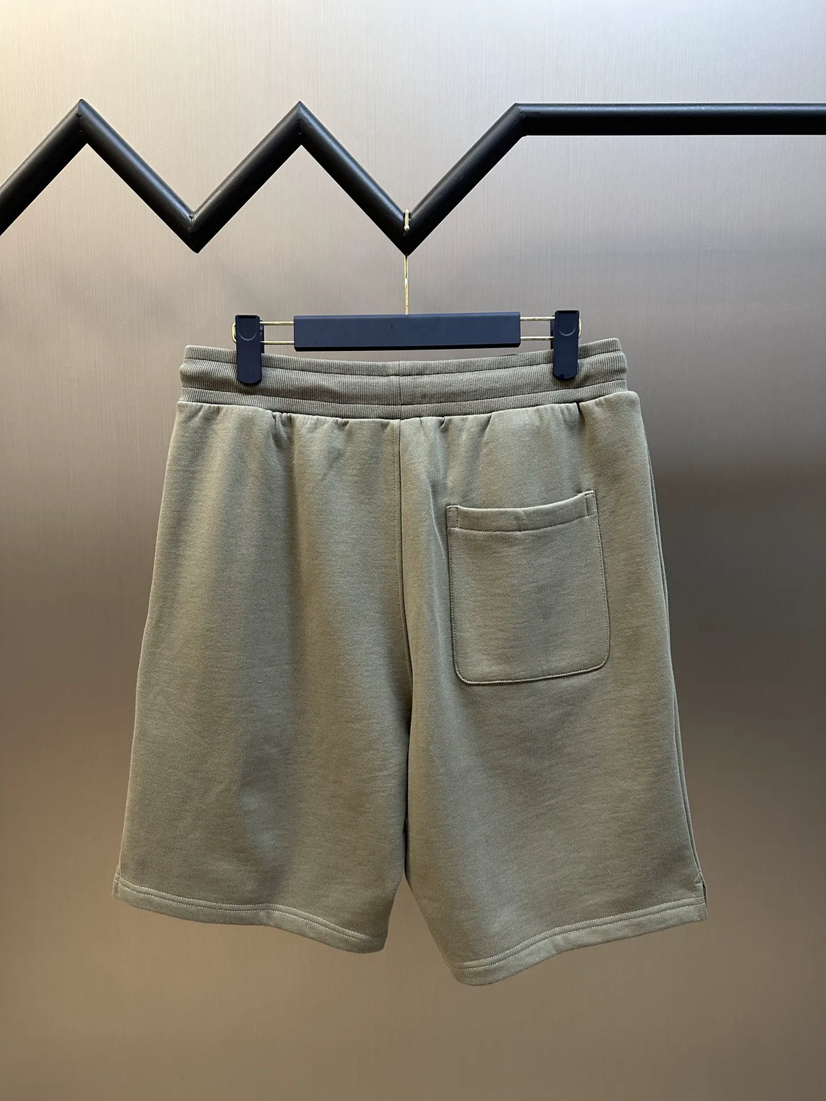 Light taupe elastic waist shorts with single rear patch pocket