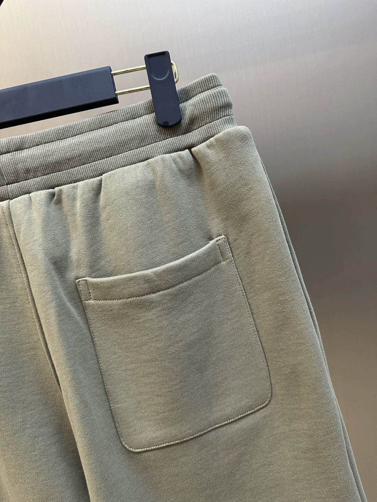 Light taupe shorts close-up showing front pocket seam and waistband