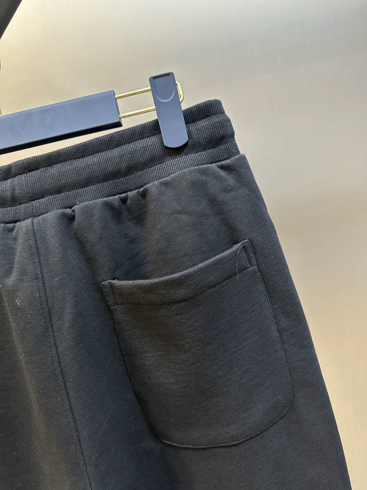 Dark shorts close-up showing front pocket and smooth knit fabric