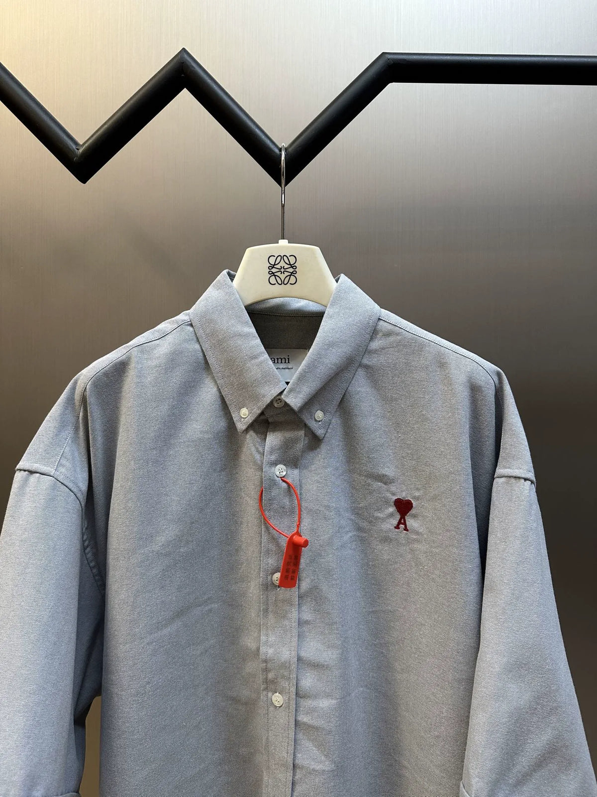 Light gray short-sleeve button-up shirt on hanger, collar and button placket visible