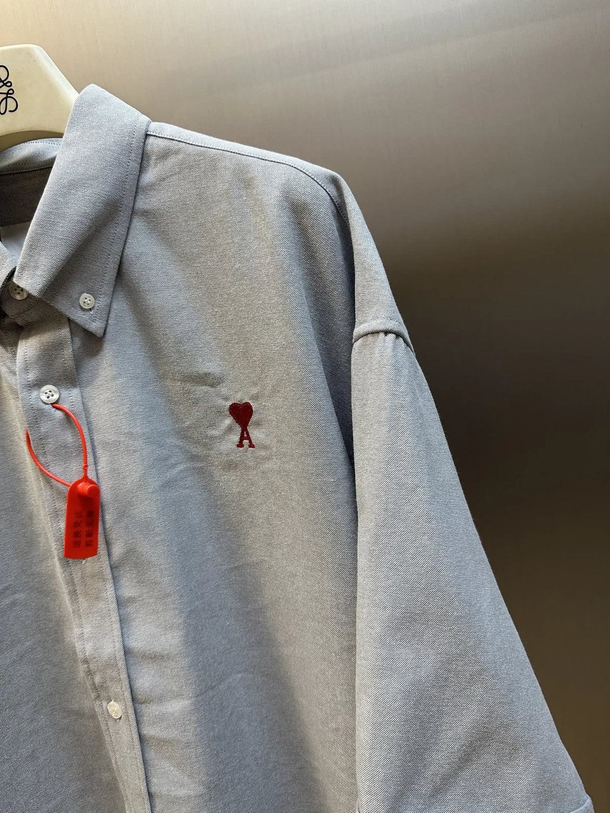 Light gray short-sleeve button-up shirt with red dog-bone embroidery on chest
