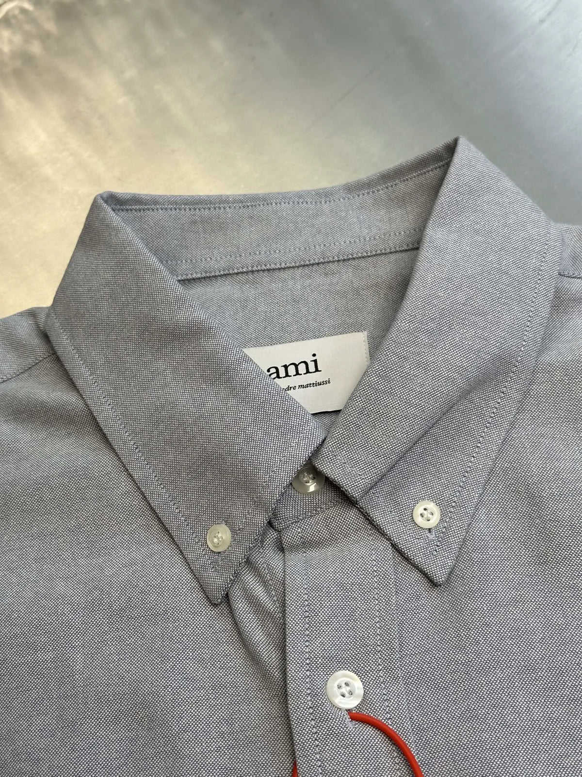 Light gray button-up shirt with pointed collar and white buttons at placket